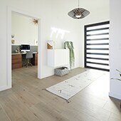 Foyer with wood look tile floor and striped rug