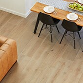 Birds eye view of dining room with light colored wood look tile floor and modern furniture