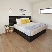 Bedroom with light colored wood look tile on the floor with contemporary furnishings