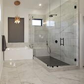 Bathroom with large format marble look porcelain tile flooring and shower walls